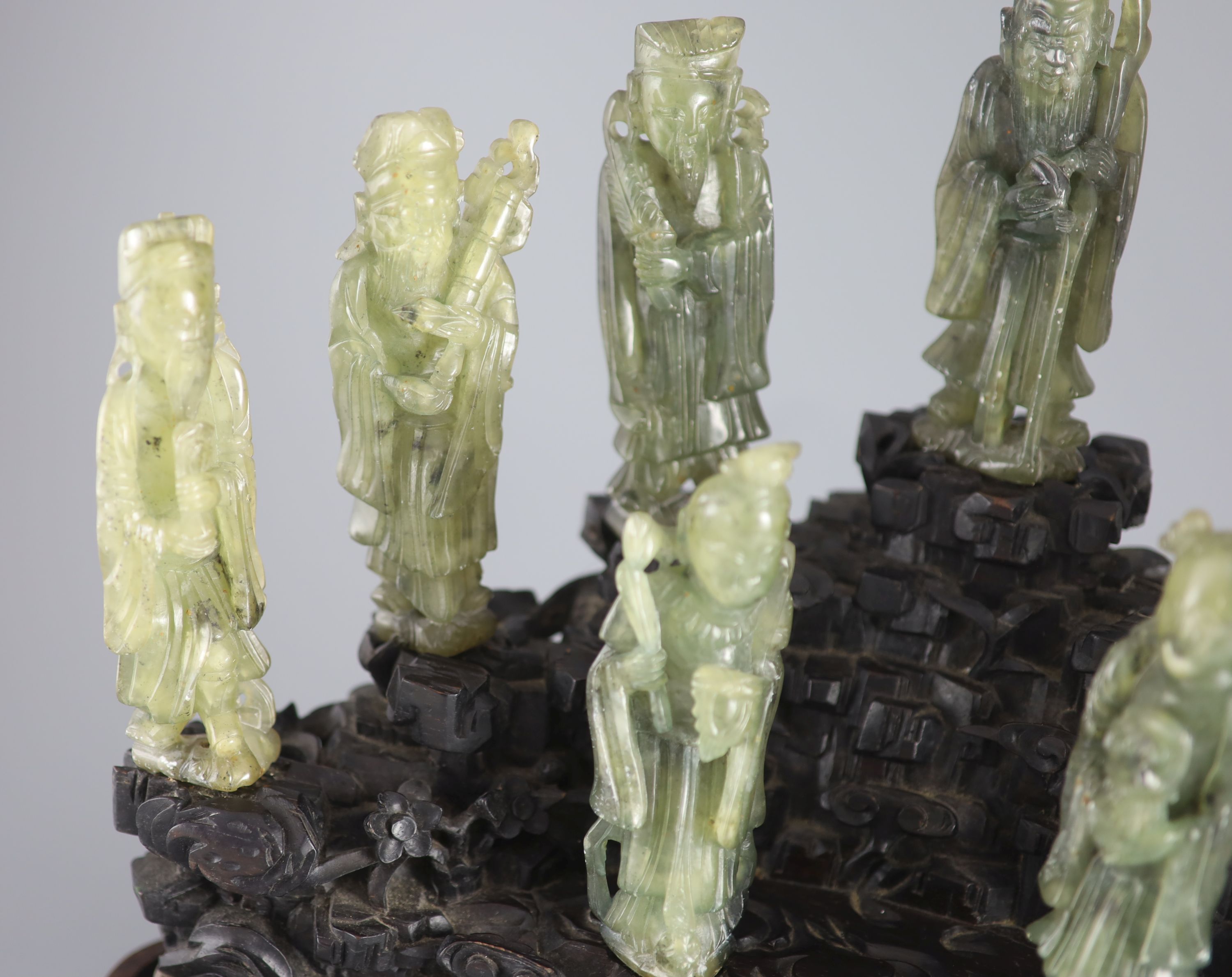 A set of nine Chinese soapstone figures of the Eight Immortals and Shou Lao, on a good zitan two piece rockwork stand, late Qing dyna